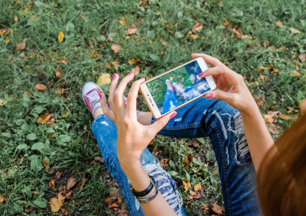 image illustrative smartphone , navigation sur les réseaux sociaux, jeune femme avec un smartphone dans les mains.