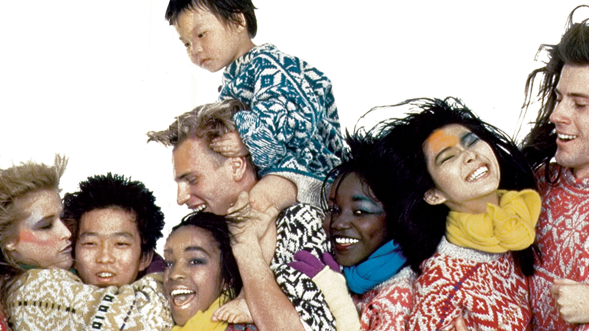 Photographie pour la campagne "toutes les couleurs du monde" de Benetton représentant des personnes de couleurs différentes et de cultures différentes ensemble et heureuses.
